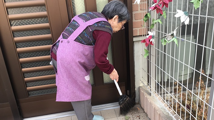 玄関を掃除するご利用者さま